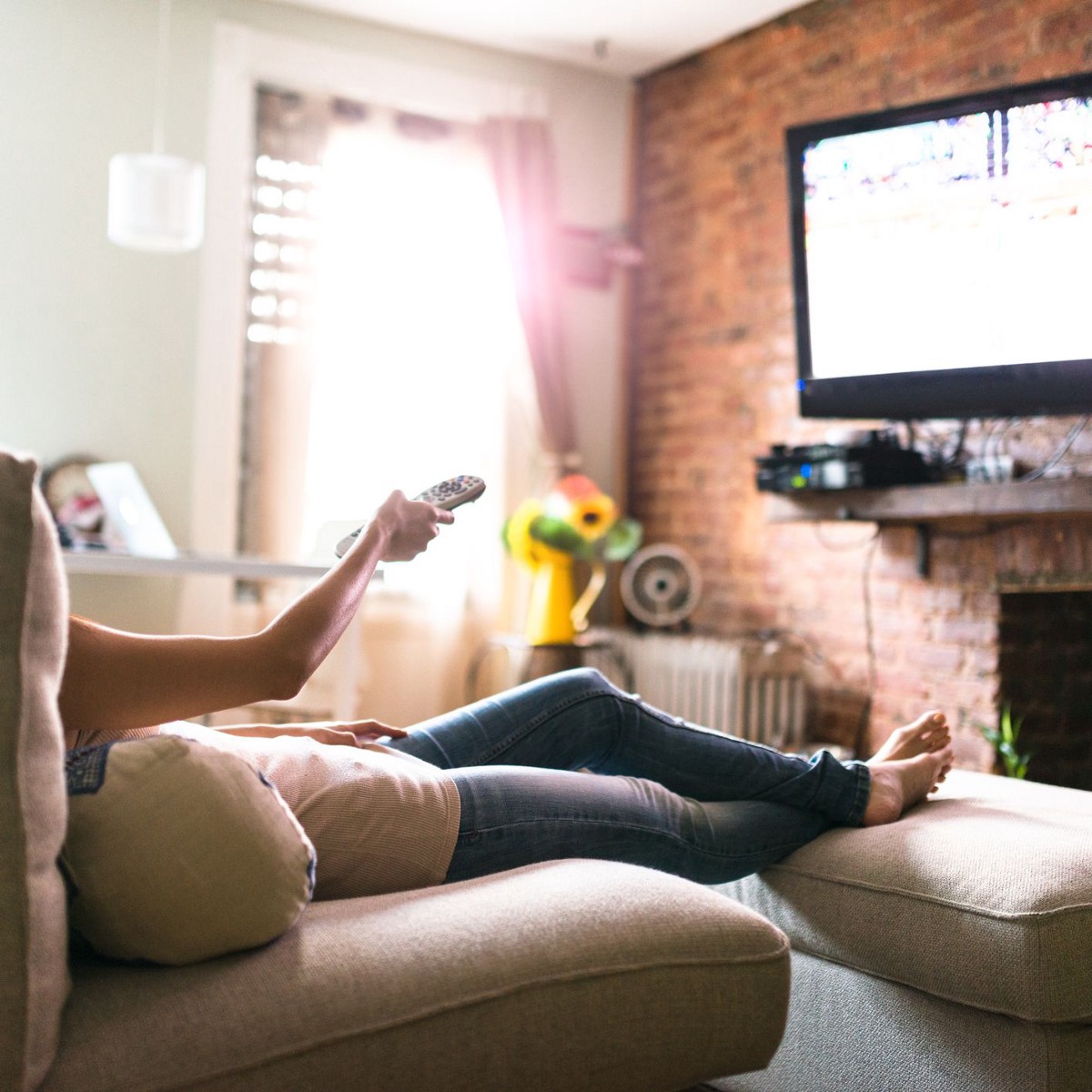 Girl sitting in front of a TV with remote